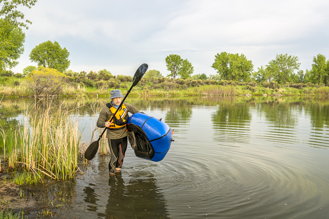 senior male carrying a packraft