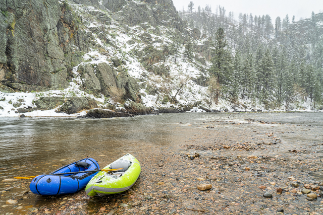 inflatable whitewater kayak and packraft in snowstorm