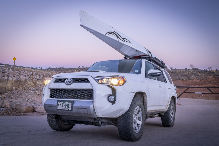 Fort Collins, CO, USA - December 21, 2023: Toyota 4runner SUV with a rowing shell, LiteRace 1x by Liteboat on roof racks on a shore of Horsetooth Reservoir - fall or winter dusk scenery.