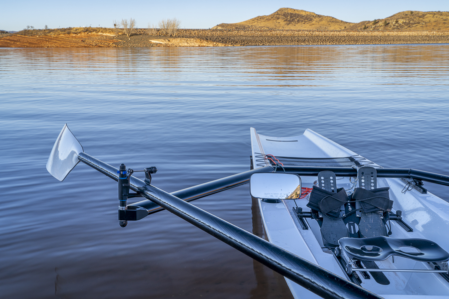 Coastal rowing shell on a shore of Horsetooth Reservoir in fall or winter scenery with a low water level.